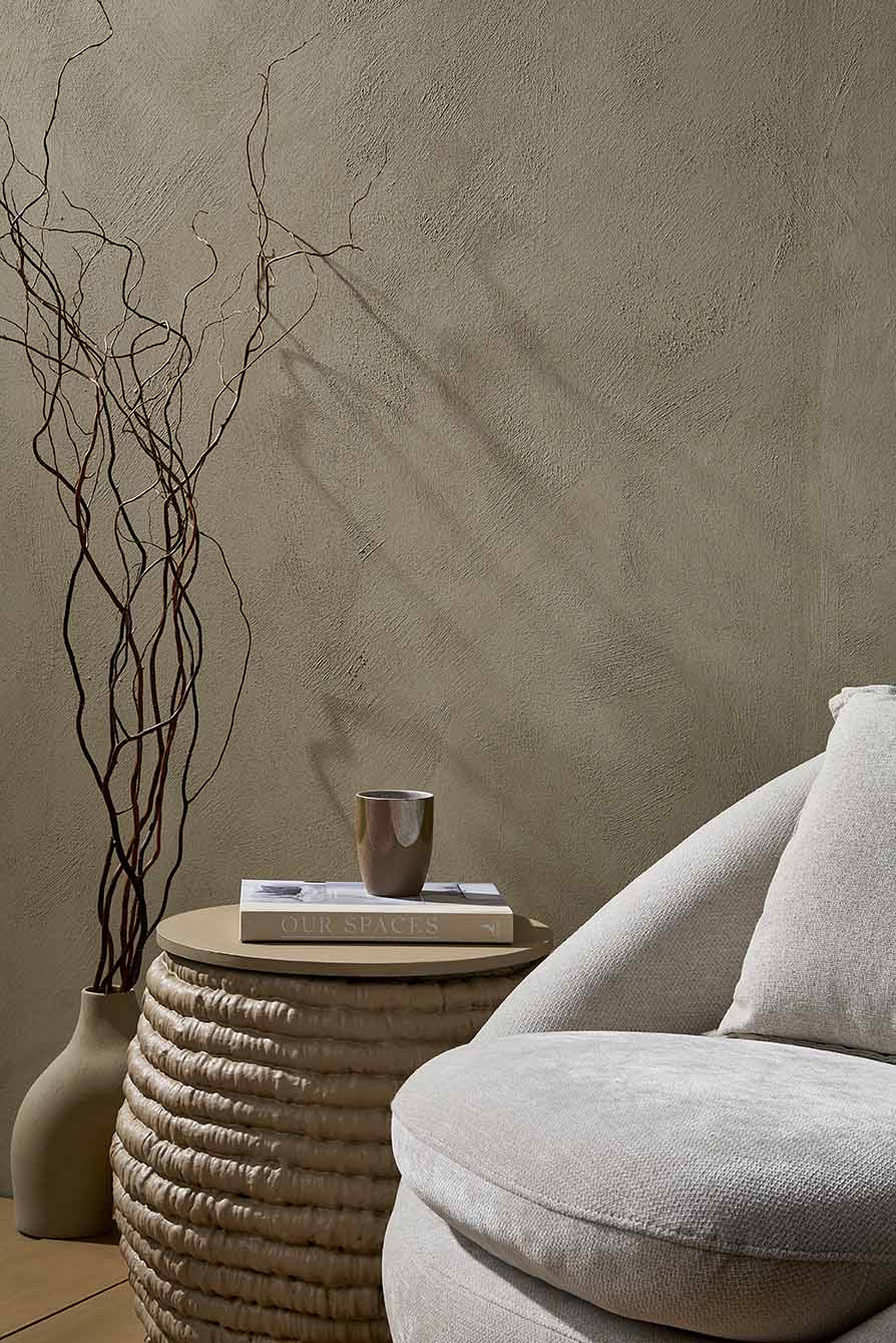 Warm interior vignette — rounded linen chair and woven basket side table